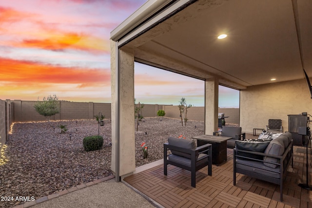 patio terrace at dusk featuring an outdoor living space