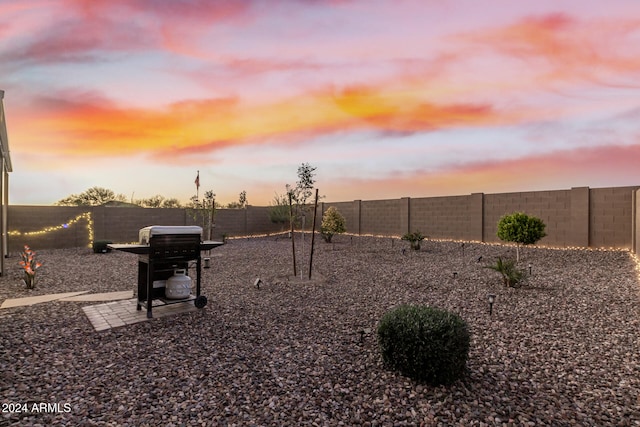 yard at dusk featuring a patio