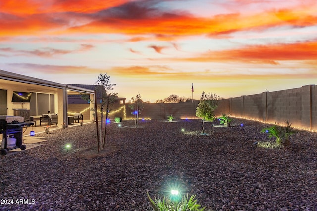 yard at dusk featuring a patio area