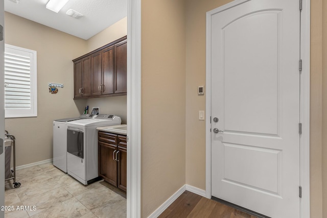 laundry area featuring washing machine and dryer and cabinets