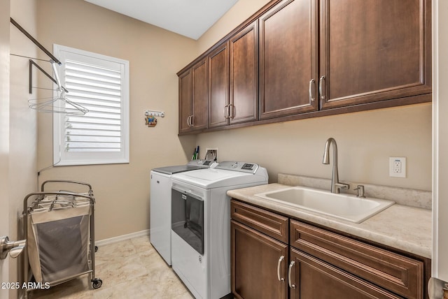 laundry area featuring cabinets, independent washer and dryer, and sink