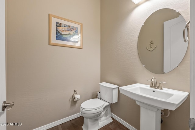 bathroom with toilet and wood-type flooring