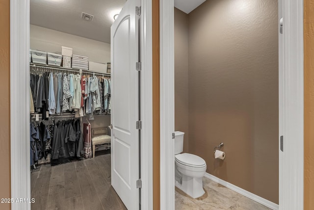 bathroom featuring toilet and wood-type flooring