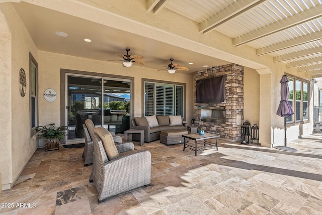 view of patio / terrace with an outdoor living space with a fireplace and ceiling fan