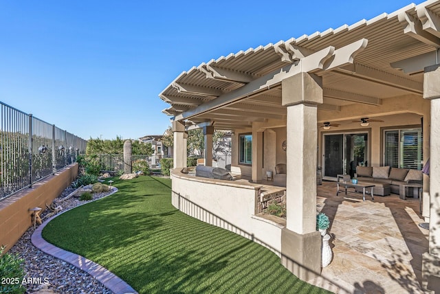 view of yard with outdoor lounge area, ceiling fan, exterior kitchen, and a patio