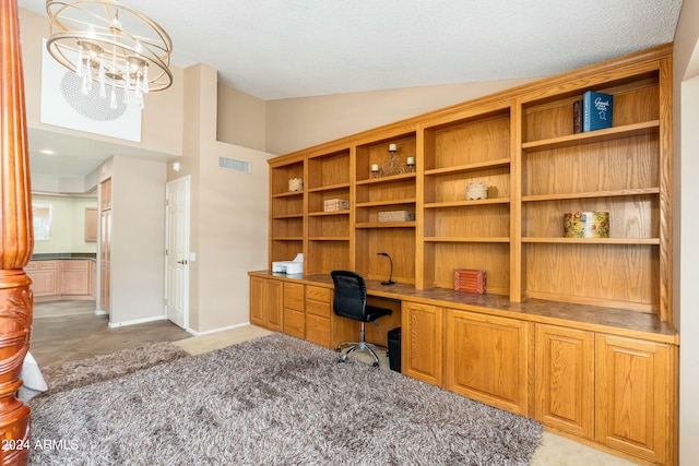 carpeted office space with a textured ceiling, built in desk, vaulted ceiling, and an inviting chandelier