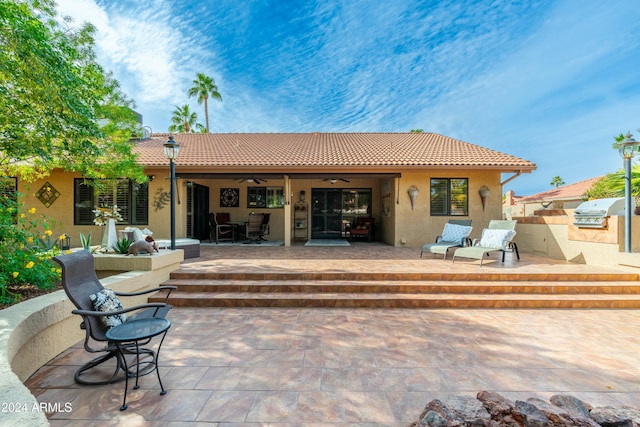 rear view of house featuring ceiling fan, exterior kitchen, and a patio