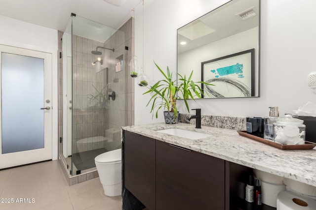 bathroom with toilet, a stall shower, tile patterned flooring, and vanity