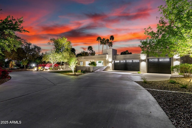 view of front facade featuring driveway, stucco siding, and an attached garage