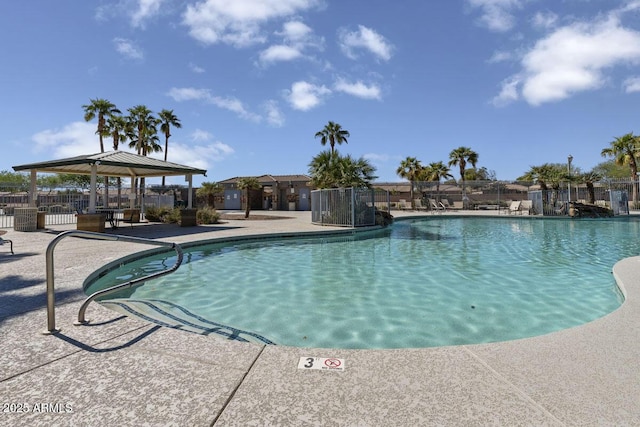 community pool with fence, a gazebo, and a patio