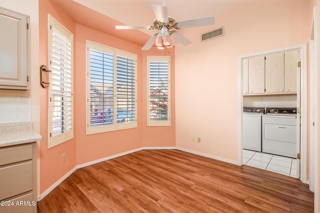 unfurnished dining area with baseboards, visible vents, ceiling fan, light wood-style floors, and washer and clothes dryer