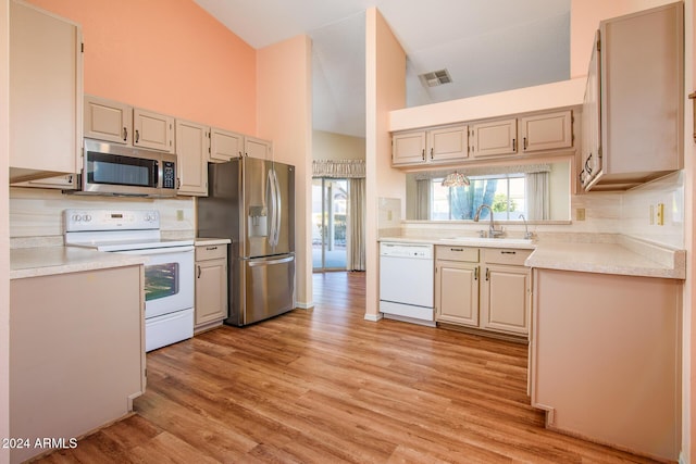 kitchen with visible vents, a sink, appliances with stainless steel finishes, light countertops, and lofted ceiling