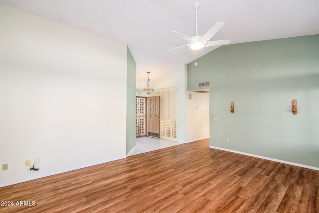 empty room featuring visible vents, high vaulted ceiling, ceiling fan, and wood finished floors