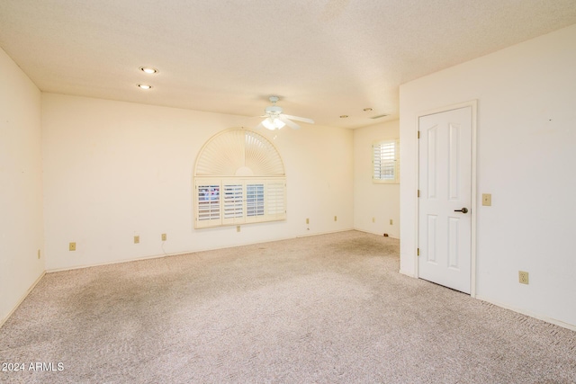 spare room with carpet flooring, a textured ceiling, and a ceiling fan