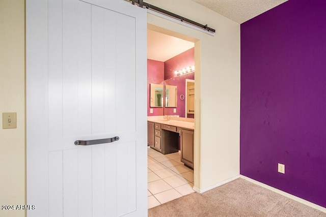 bathroom with tile patterned flooring, a textured ceiling, vanity, and baseboards