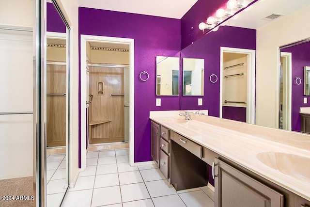 bathroom with visible vents, a stall shower, a sink, and double vanity