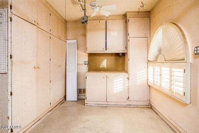 kitchen with a wealth of natural light, unfinished concrete floors, light countertops, and ceiling fan