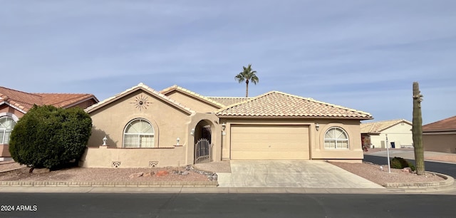 mediterranean / spanish-style house with concrete driveway, a tiled roof, a garage, and stucco siding