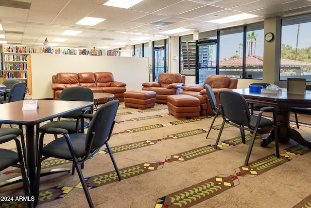 dining space featuring a drop ceiling, plenty of natural light, and carpet floors