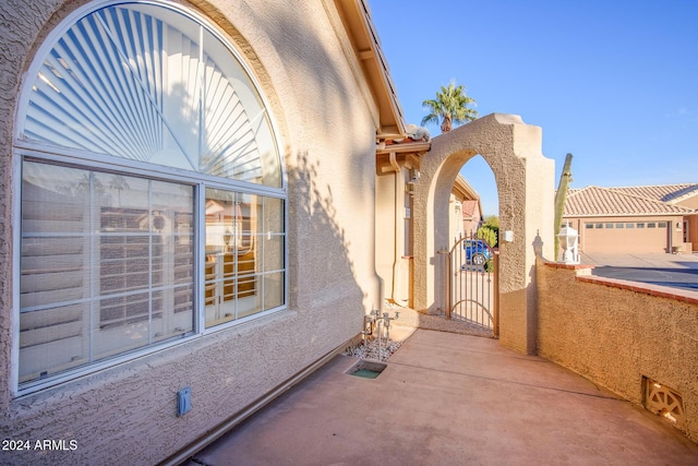 view of patio / terrace featuring a garage and a gate