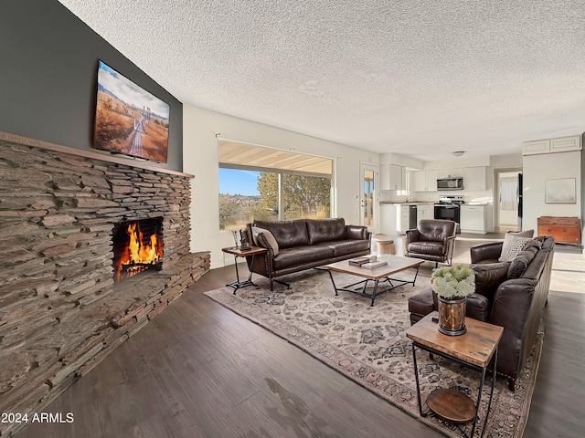 living room featuring a textured ceiling, a fireplace, and dark wood-type flooring