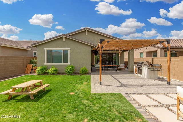 9418 W Minnezona Ave, Phoenix, AZ 85037 - back of property featuring a pergola, an outdoor kitchen, stucco siding, and a patio area
