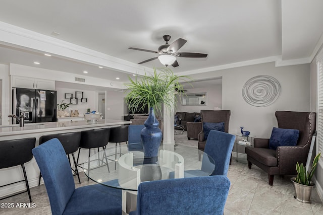 dining room featuring ornamental molding, sink, and ceiling fan