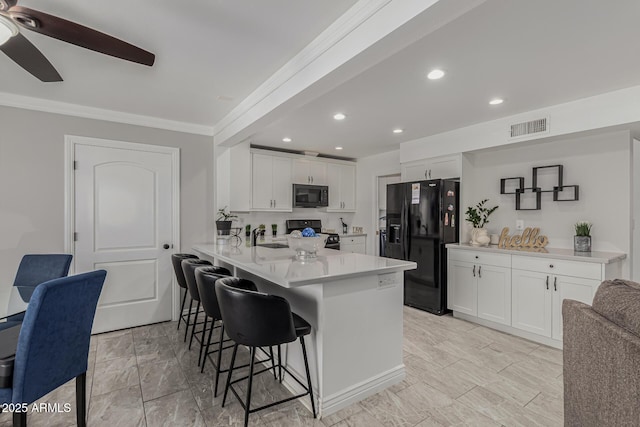 kitchen featuring white cabinetry, kitchen peninsula, and black appliances