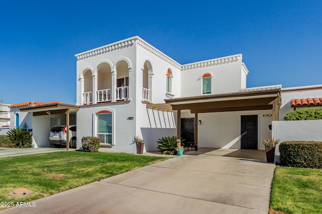 mediterranean / spanish home featuring a carport, a balcony, and a front lawn