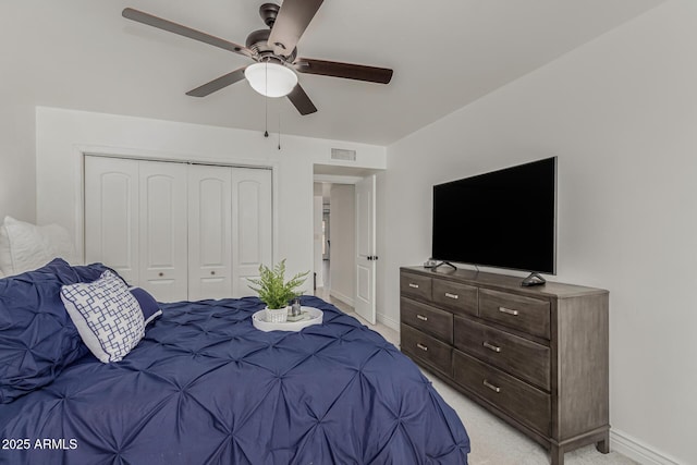 carpeted bedroom featuring a closet and ceiling fan