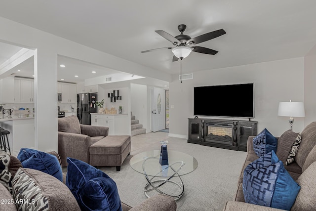 living room with light carpet and ceiling fan