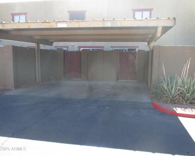 garage featuring covered parking and fence