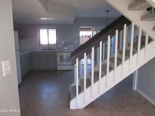 stairs featuring tile patterned flooring and baseboards