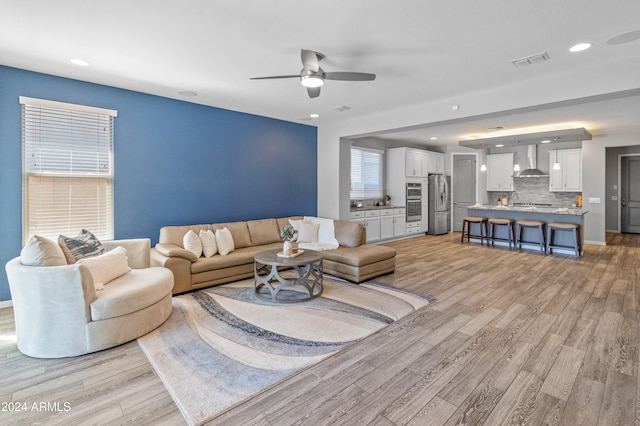 living room featuring ceiling fan and light hardwood / wood-style flooring