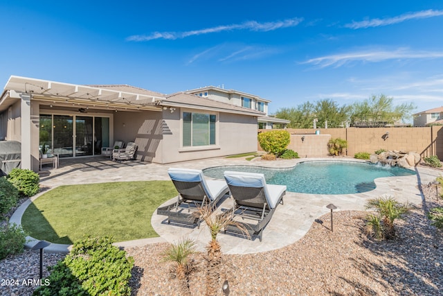 view of swimming pool with a yard, pool water feature, and a patio area