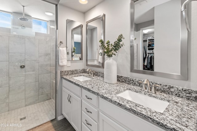 bathroom with vanity, hardwood / wood-style flooring, and tiled shower