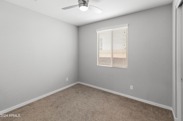 spare room with ceiling fan and carpet