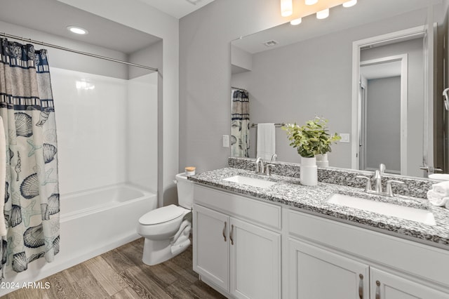 full bathroom featuring vanity, toilet, wood-type flooring, and shower / bathtub combination with curtain