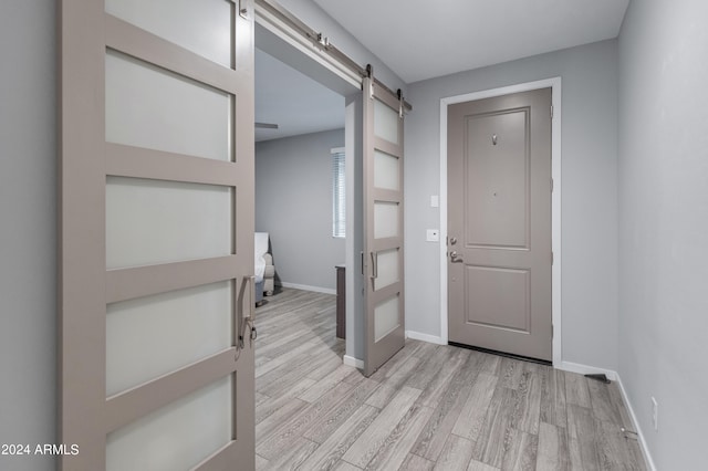 foyer with light hardwood / wood-style floors and a barn door