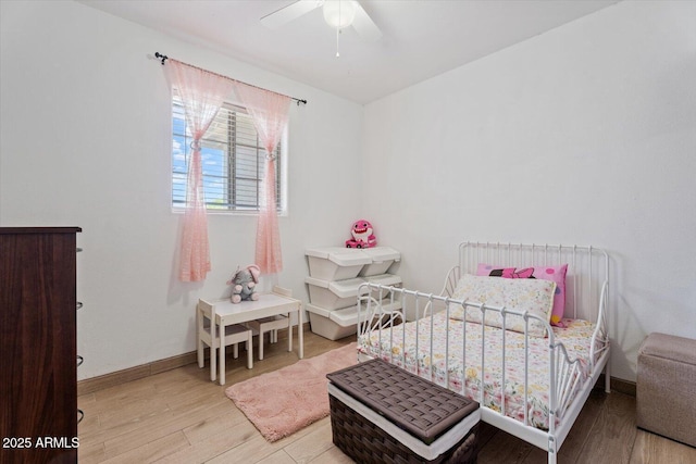 bedroom with baseboards, a ceiling fan, and light wood-style floors