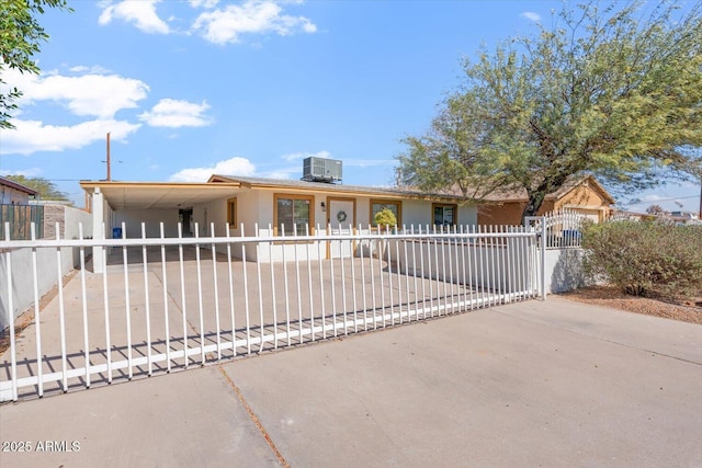 ranch-style house featuring driveway, a fenced front yard, a gate, and cooling unit