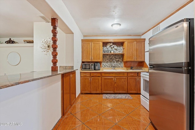 kitchen with brown cabinets, open shelves, stainless steel appliances, tasteful backsplash, and a sink