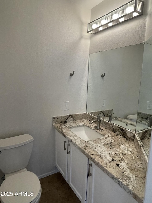 bathroom featuring tile patterned floors, toilet, vanity, and baseboards