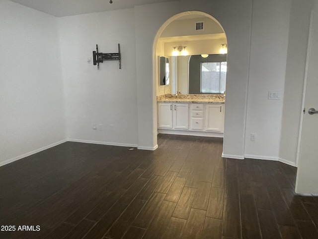 interior space featuring visible vents, baseboards, wood finished floors, and vanity