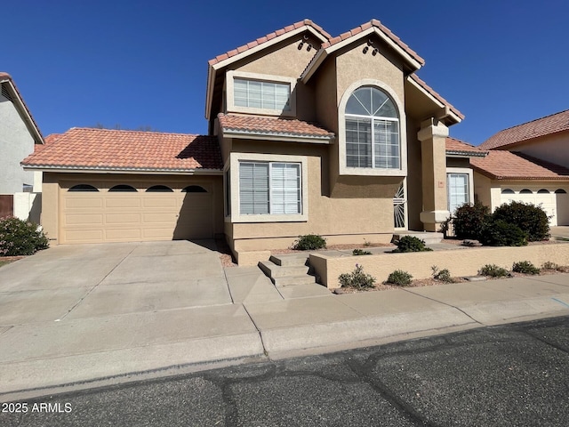 mediterranean / spanish home with stucco siding, an attached garage, a tile roof, and concrete driveway