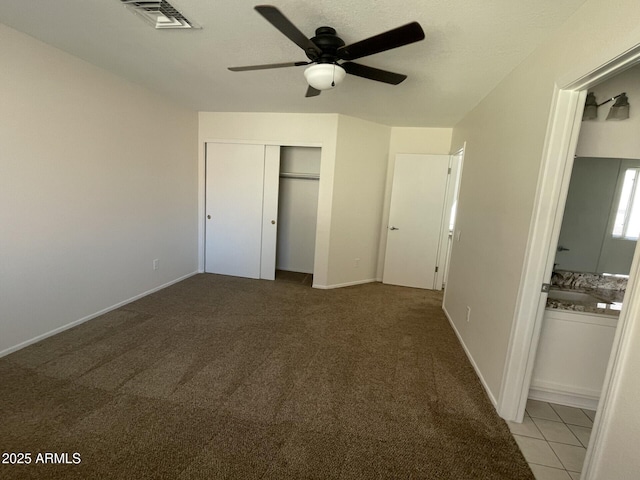 unfurnished bedroom with baseboards, visible vents, light carpet, and a closet