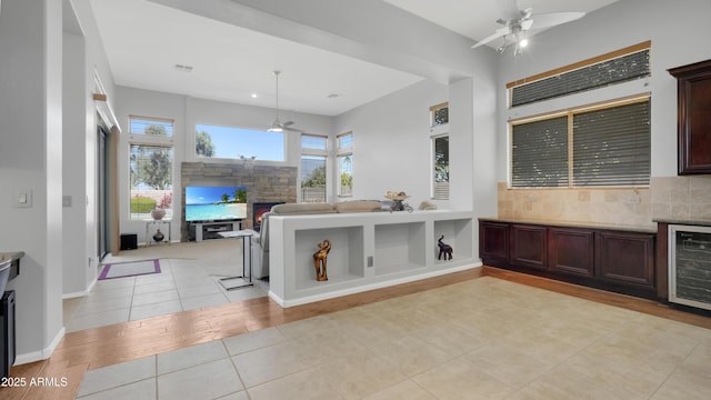 4276 E Meadowview Dr, Gilbert, AZ 85298 - bathroom featuring ceiling fan, tasteful backsplash, tile patterned flooring, a fireplace, and beverage cooler