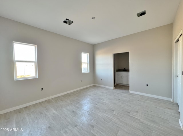 empty room featuring a healthy amount of sunlight and light wood-type flooring