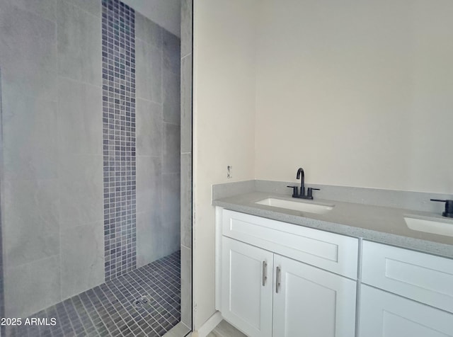 bathroom with vanity and a tile shower