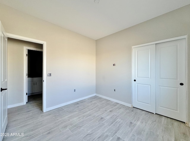 unfurnished bedroom with a closet and light wood-type flooring